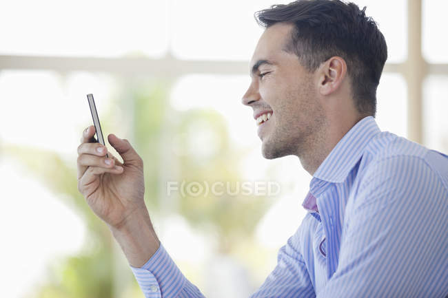 Бізнесмен використовує мобільний телефон в сучасному офісі — стокове фото