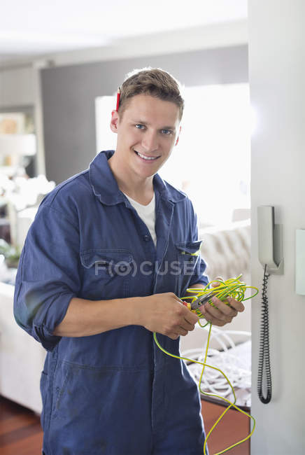 Skillful caucasian electrician working on telephone in home — Stock Photo