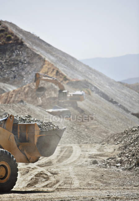Escavadores que trabalham na pedreira durante o dia — Fotografia de Stock