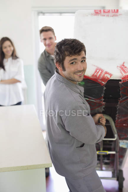 Geschickter kaukasischer Arbeiter, der Haushaltsgeräte in der Küche bewegt — Stockfoto