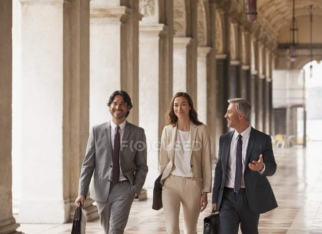 Gente sonriente de negocios caminando por el pasillo - foto de stock