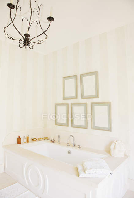Lámpara de araña sobre bañera en baño de lujo - foto de stock