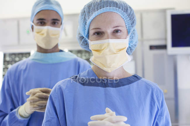 Cirujanos de pie en quirófano moderno - foto de stock