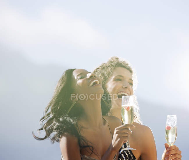 Jeunes femmes attrayantes buvant du champagne ensemble à l'extérieur — Photo de stock