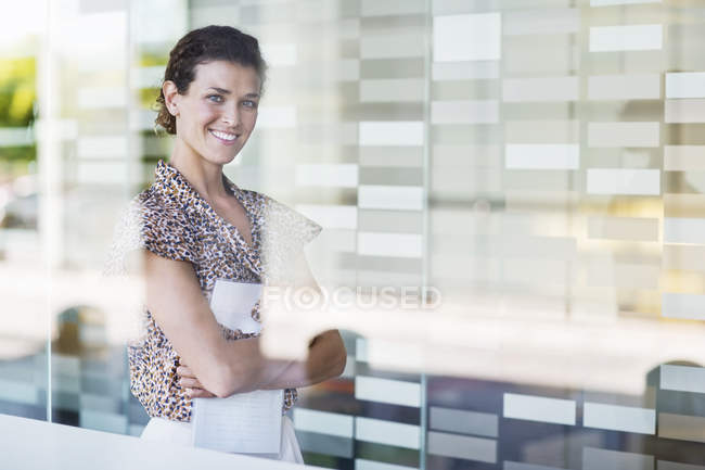 Бізнес-леді посміхається в офісі в сучасному офісі — стокове фото