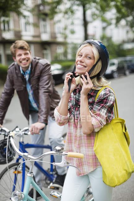 Mujer sujeción casco de bicicleta - foto de stock