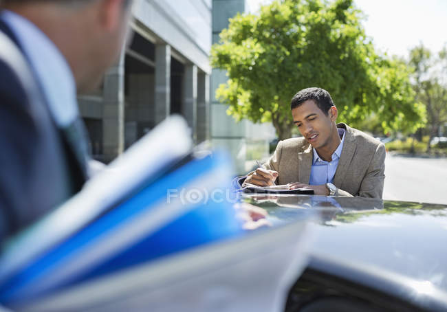 Successful business people talking at car — Stock Photo