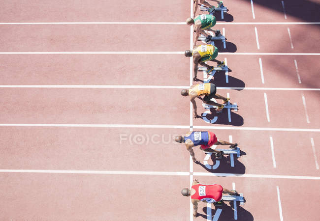 Runners waiting at starting block on track — Stock Photo