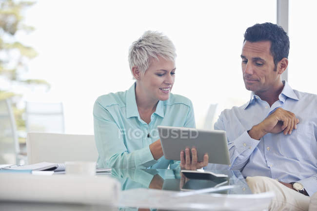 Business people using tablet computer on sofa — Stock Photo