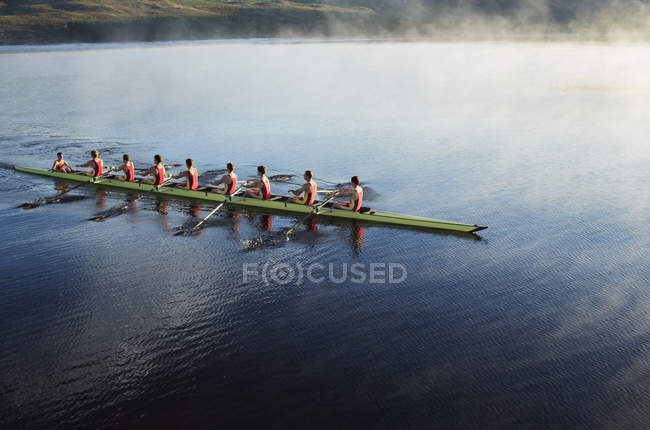 Rowing crew rowing scull on lake — Stock Photo