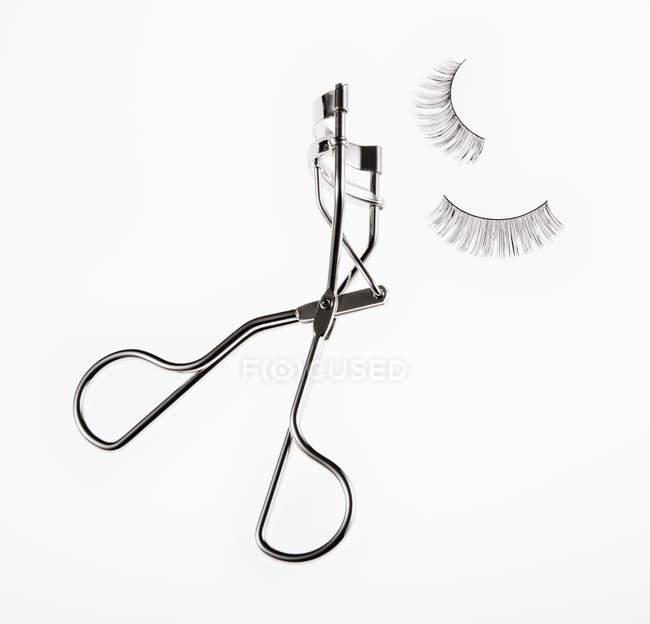 Eyelash curler and false eyelashes on white background — Stock Photo