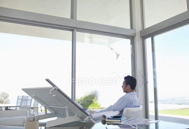 Geschäftsmann blickt aus dem Fenster auf modernes Büro — Stockfoto