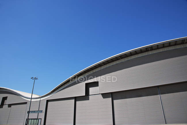 Curved roof of warehouse and blue sky — Stock Photo