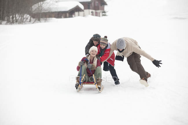 Счастливые семейные санки на снежном поле — стоковое фото
