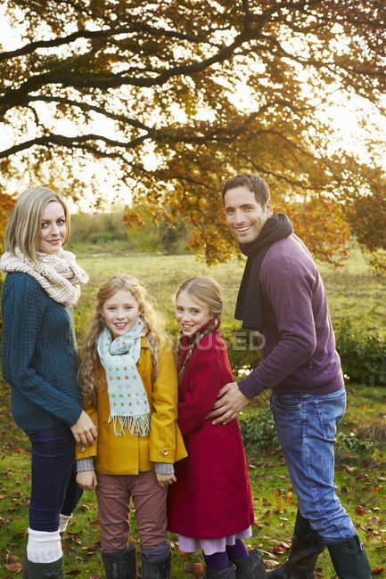 Family posing at countryside lawn at autumn day — Stock Photo
