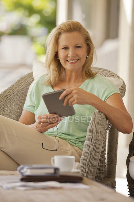 Портрет усміхненої жінки з використанням цифрового планшета на ганку — стокове фото