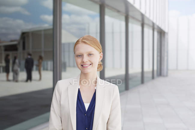 Retrato de una mujer de negocios sonriente fuera del edificio - foto de stock