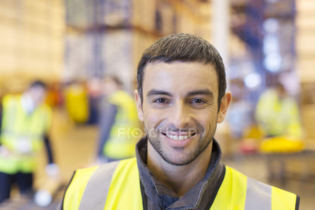 Trabajador sonriendo en el almacén - foto de stock