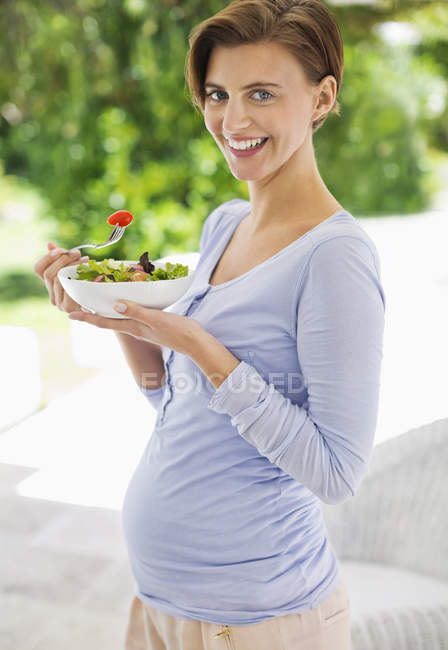 Donna incinta che mangia insalata — Foto stock