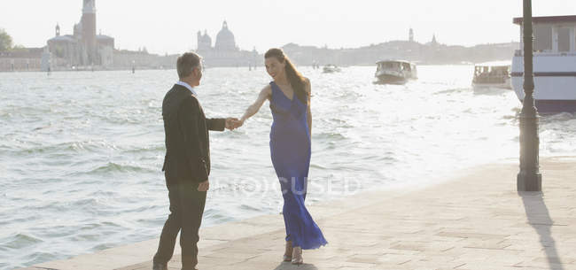 Hombre y mujer bien vestidos en el paseo marítimo de Venecia - foto de stock