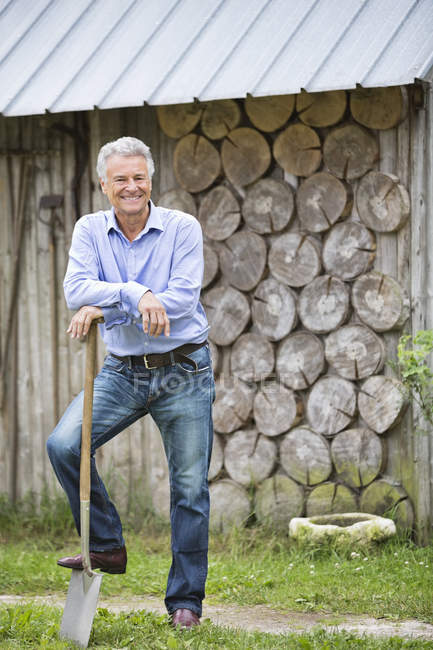 Чоловік стоїть з лопатою на відкритому повітрі — стокове фото