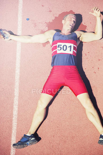 Runner laying on track after running — Stock Photo