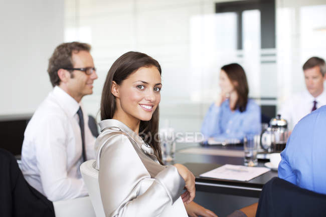 Бізнес-леді посміхається на зустрічі в сучасному офісі — стокове фото