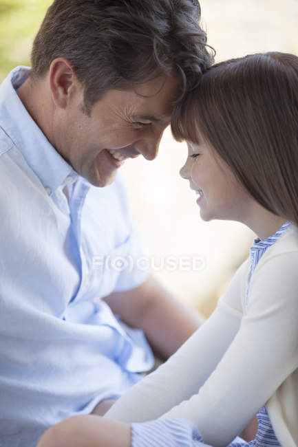 Père et fille touchant le front à l'extérieur — Photo de stock