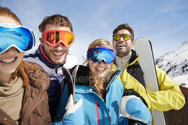 Amigos llevando esquís en la cima de la montaña - foto de stock