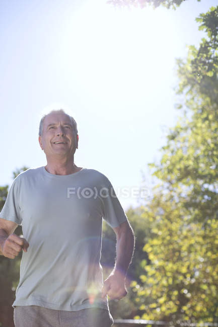 Homem caucasiano sênior correndo ao ar livre — Fotografia de Stock