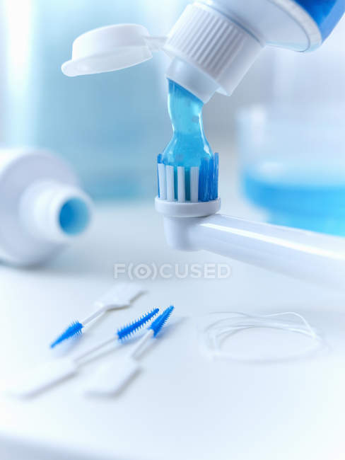Close up de pasta de dentes espremendo na escova de dentes elétrica — Fotografia de Stock