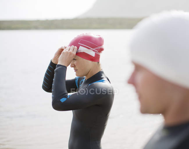 Уверенный и сильный триатлонисты тянут на очки на пляже — стоковое фото