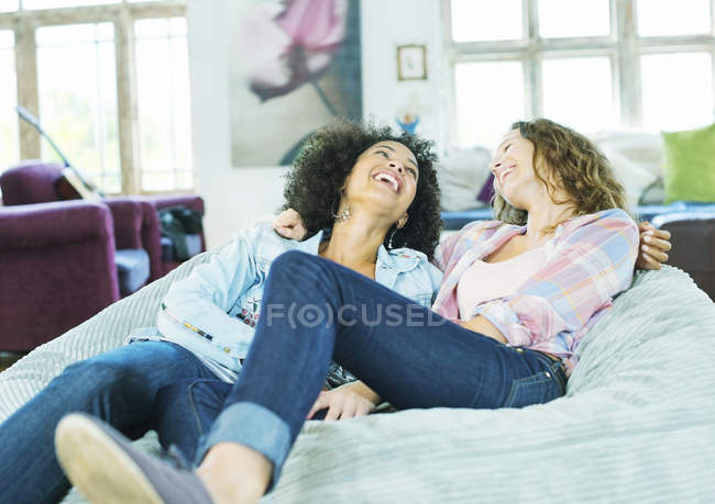 Mujeres relajándose en la silla del bolso de frijoles juntos - foto de stock
