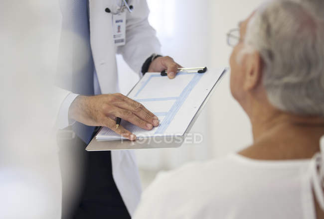 Доктор показ медичних діаграми, щоб пацієнт в лікарняній палаті — стокове фото