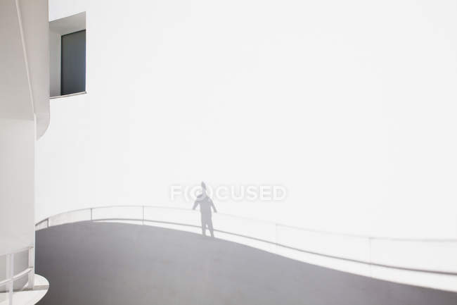 Modern architecture, shadow of businessman leaning on railing — Stock Photo