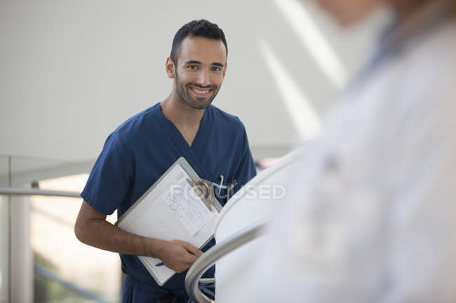 Krankenschwester trägt Klemmbrett im Krankenhausflur — Stockfoto