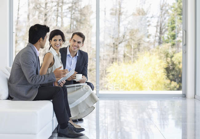 Geschäftsleute unterhalten sich auf Sofa im modernen Büro — Stockfoto