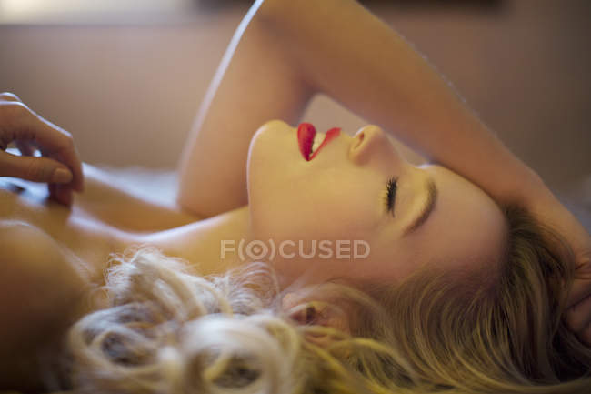 Beautiful nude woman laying on bed — Stock Photo