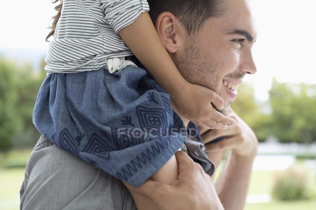 Vater trägt Tochter auf Schultern ins Freie — Stockfoto