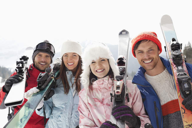 Retrato de amigos felices con esquís - foto de stock