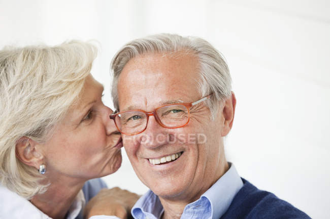 Mujer sonriente besando marido - foto de stock