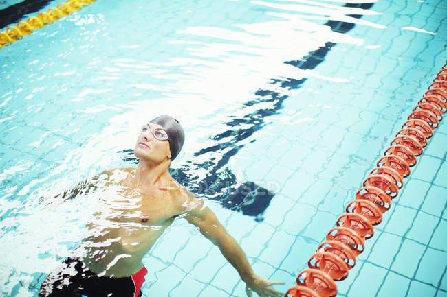 Nuotatore sul retro in acqua della piscina — Foto stock