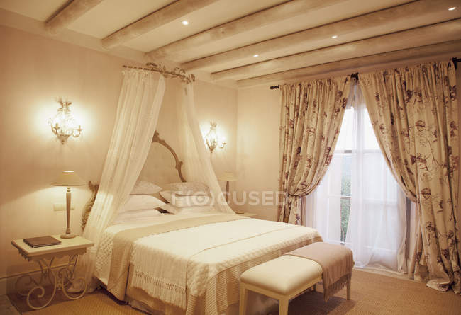 Sconces e dossel acima da cama no quarto de luxo — Fotografia de Stock