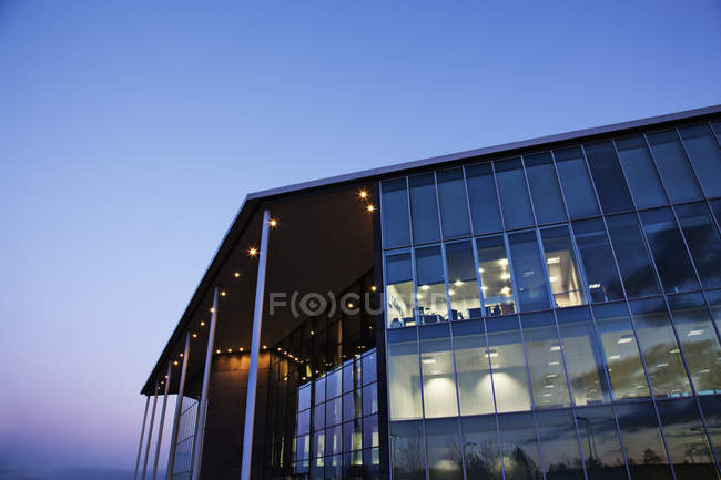 Edificio moderno iluminado al atardecer - foto de stock