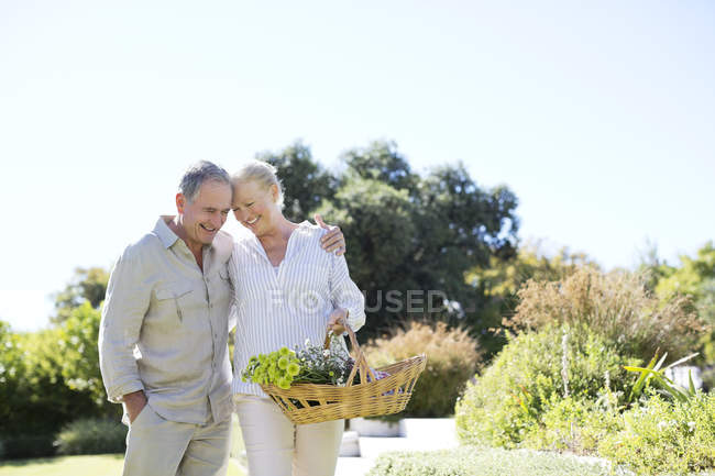 Seniorenkaukasisches Paar spaziert mit Korb im Freien — Stockfoto