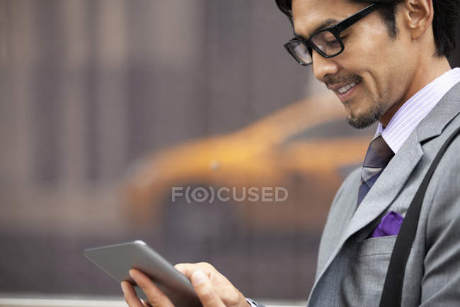 Empresário usando tablet computador na rua da cidade — Fotografia de Stock