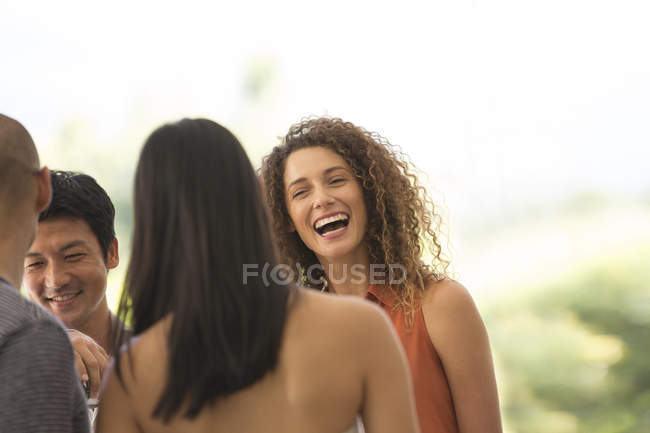 Giovani attraenti Amici che parlano alla festa — Foto stock