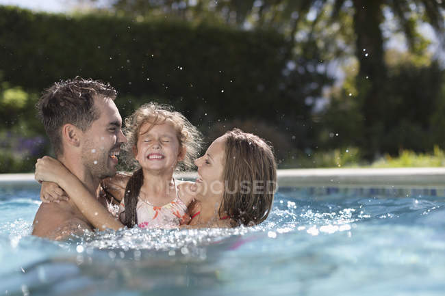 Familia jugando en la piscina - foto de stock