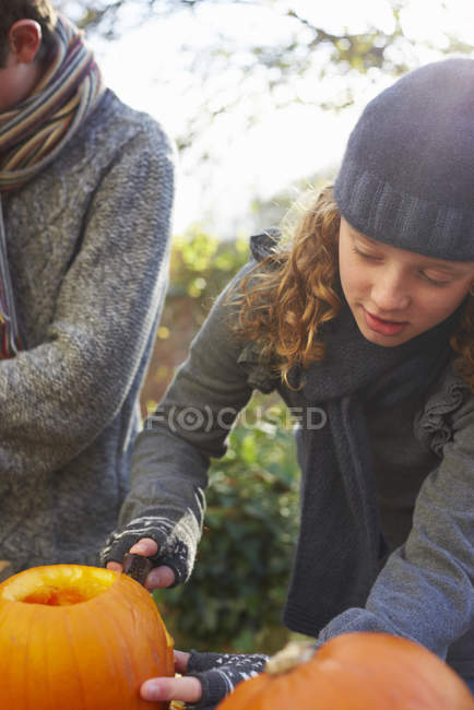 Crianças esculpindo abóboras juntas ao ar livre — Fotografia de Stock