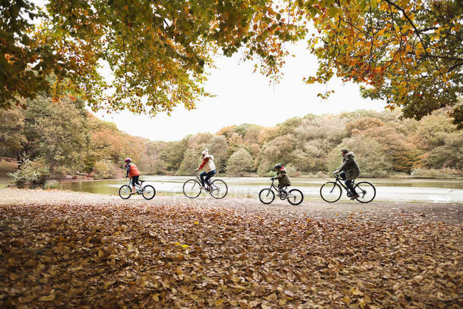 Family riding bicycles together in park — Stock Photo